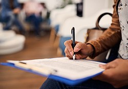 Patient filling out paperwork on a clipboard