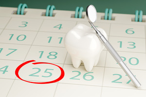 Model of tooth sitting on calendar with date circled