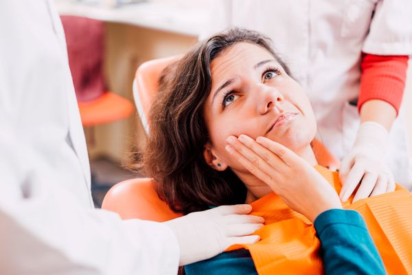 A woman with painful dry socket at the dentist’s office